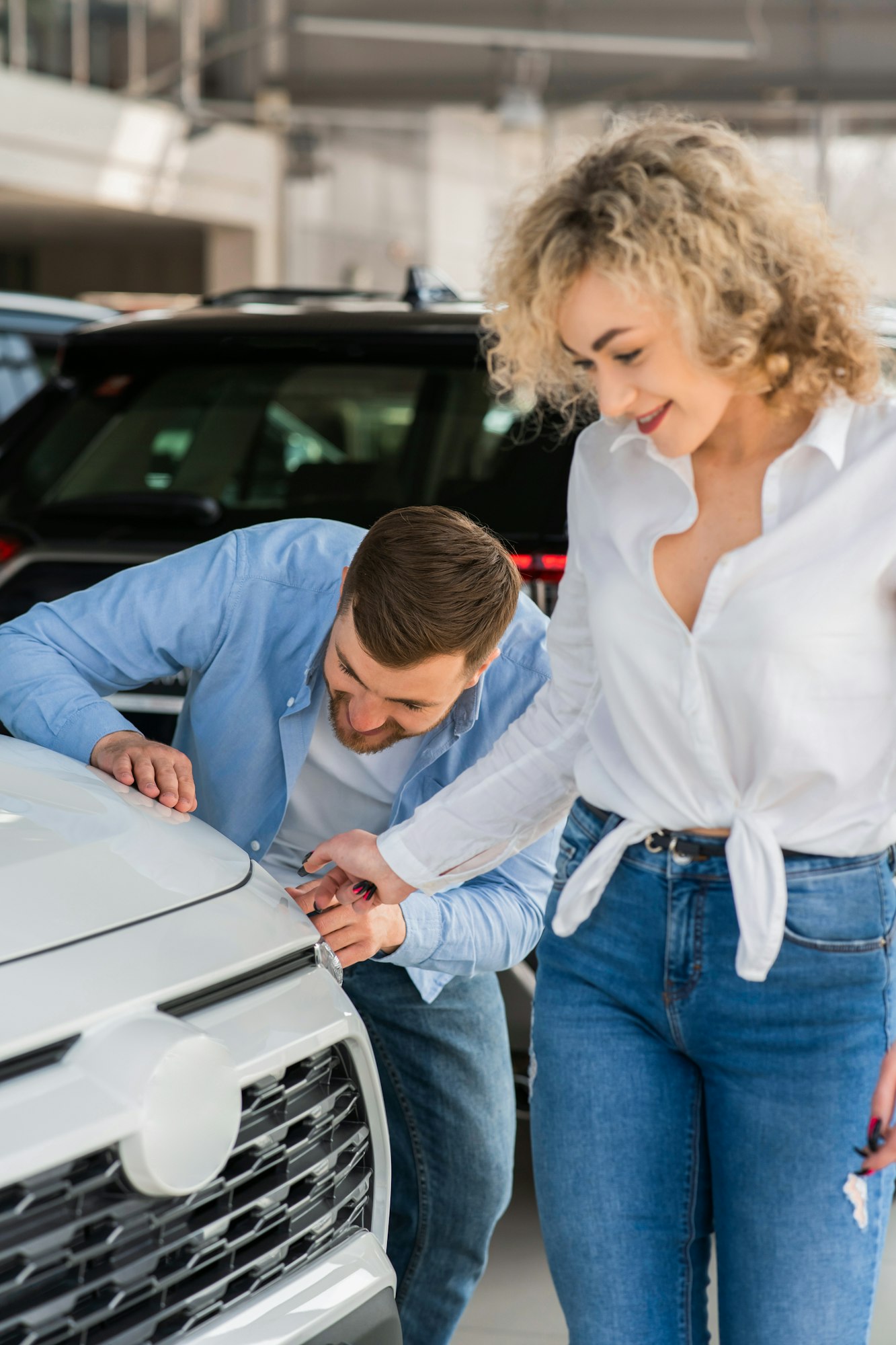 Couple looking at the new car in the dealership