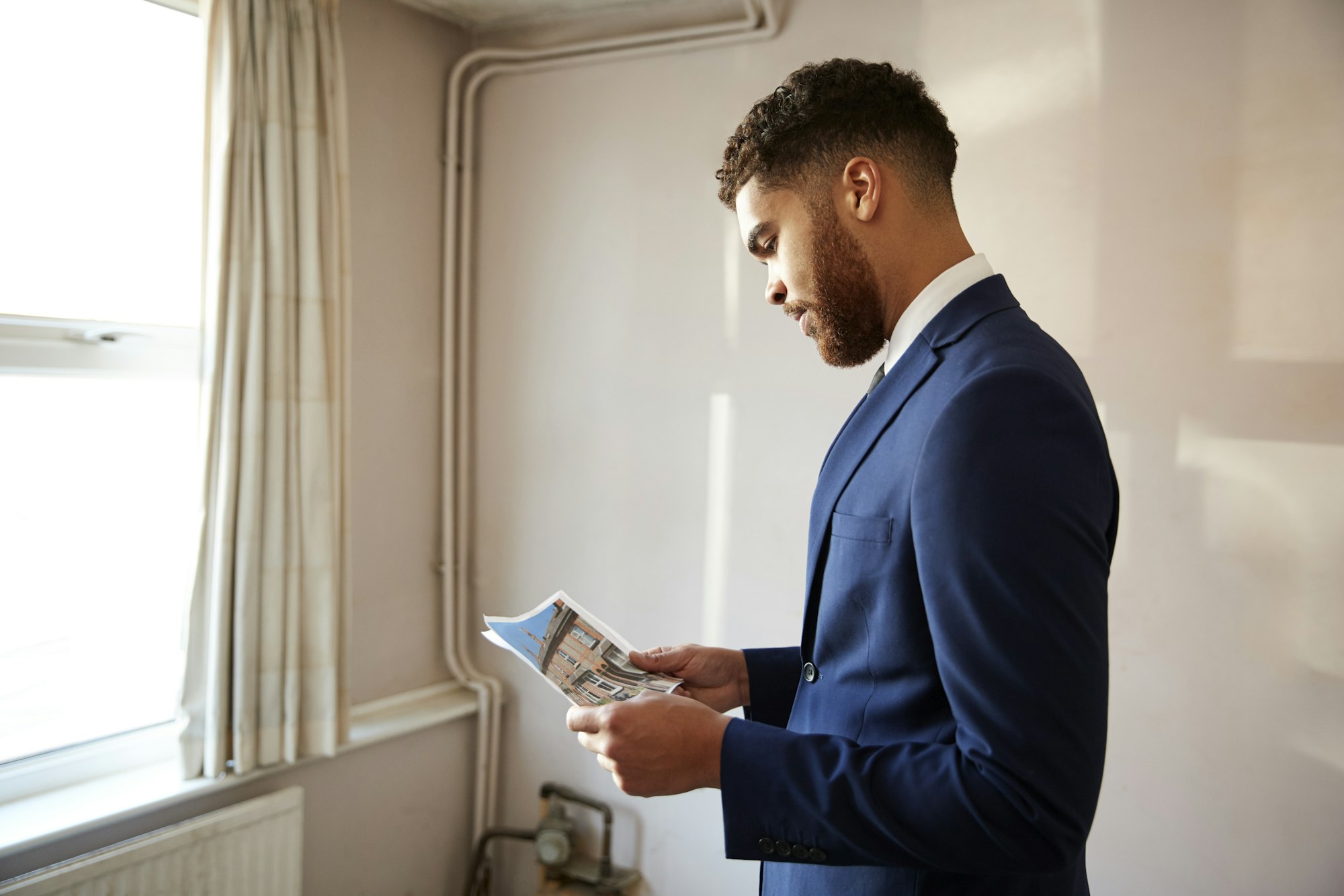 Male Realtor Looking At House Details In Property For Renovation